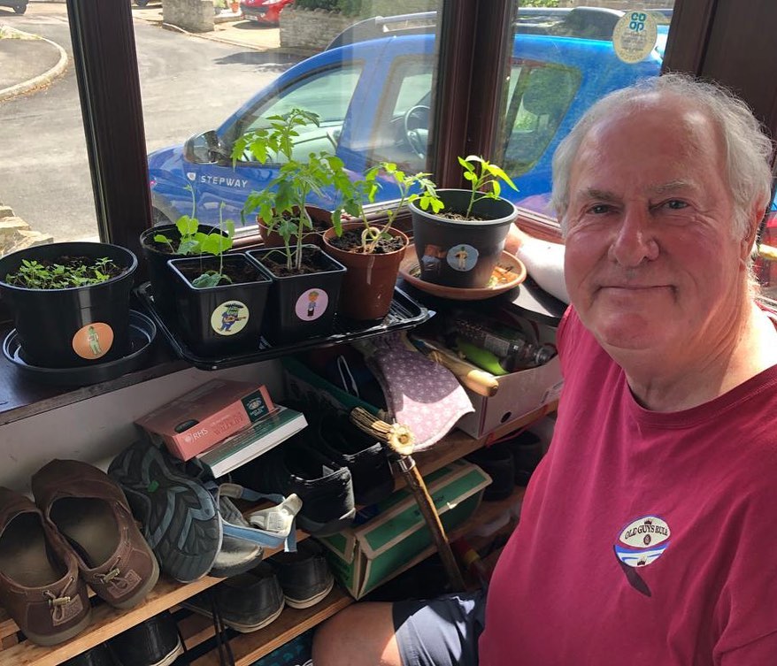 Man in green house with potted plants